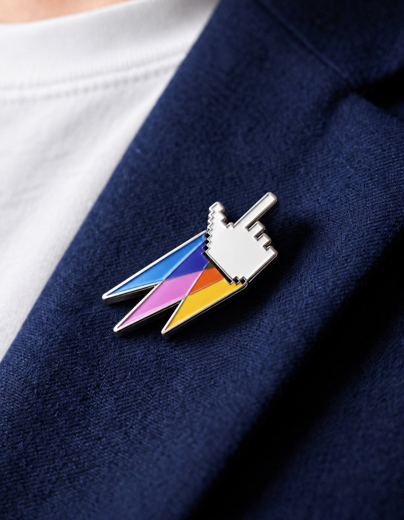 Pin’s A Kind of Magic en forme de curseur blanc prolongé d’éclairs multicolores, fixé sur une veste bleu marine.