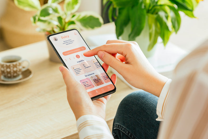 Utilisation de l’application Dulcy sur smartphone pour suivre les symptômes et accompagner un parcours de PMA.