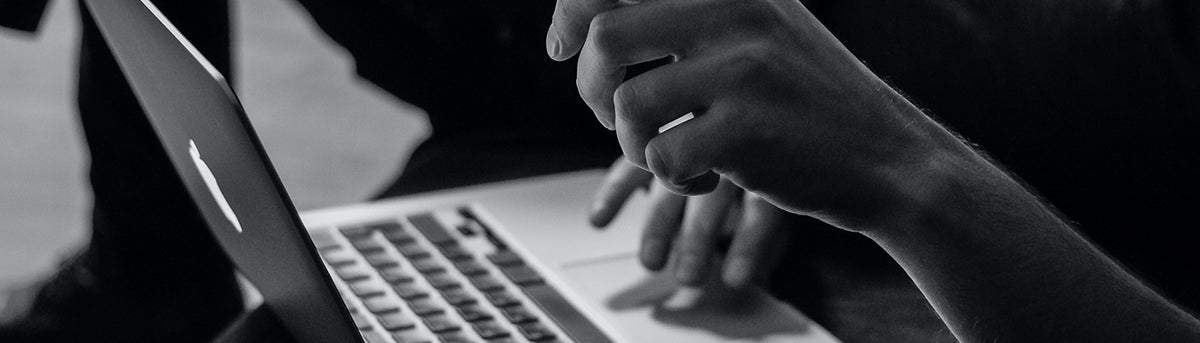 Gros plan sur un développeur travaillant sur ordinateur portable pour concevoir et automatiser des processus métier avec une solution BPM.