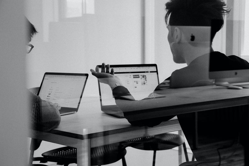Équipe technique en réunion travaillant sur ordinateurs portables autour de l’optimisation et de l’automatisation des processus métier avec une solution BPM.