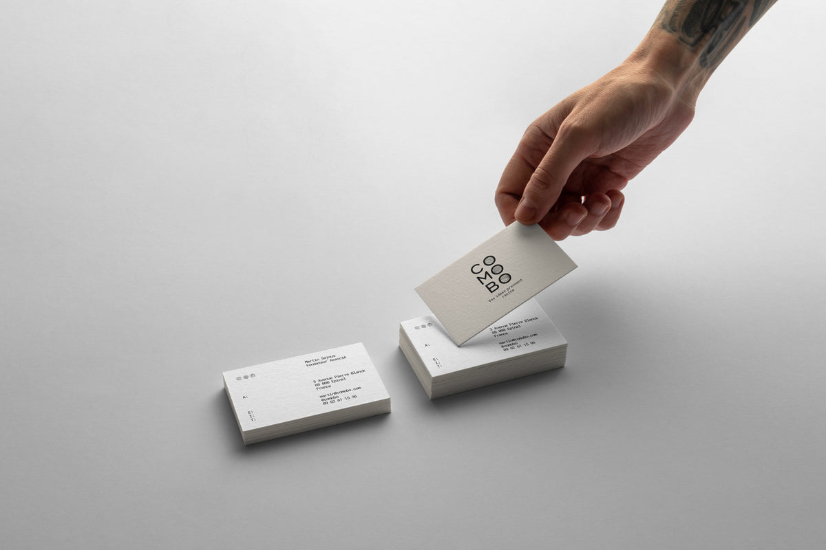 Main tenant une carte de visite blanche avec le logo 