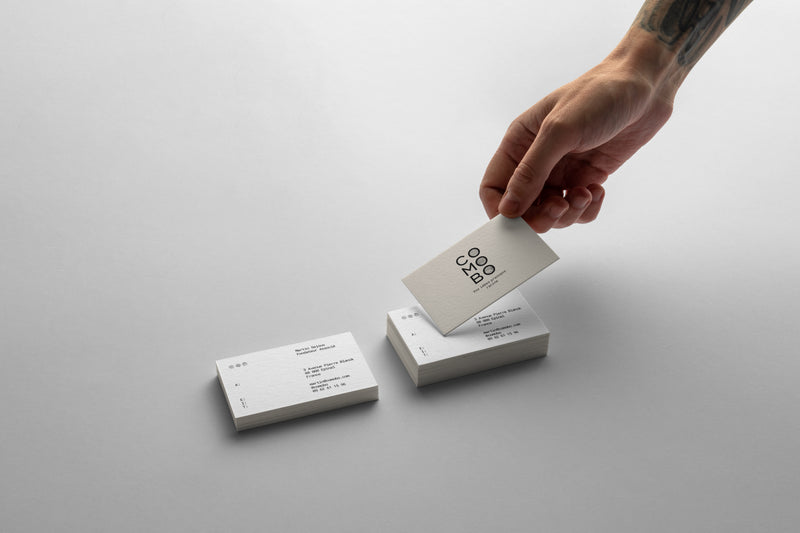 Main tenant une carte de visite blanche avec le logo 