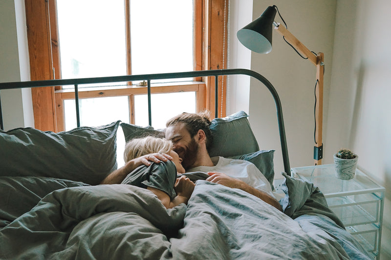 Couple enlacé dans un lit illustrant le soutien émotionnel et la relation de couple pendant un parcours de PMA.