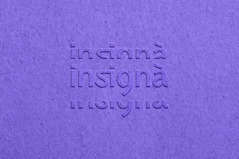 Logo Insignà gaufré en relief sur papier texturé violet.