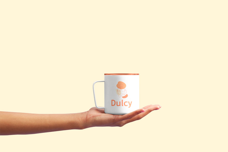 Mug Dulcy avec illustration et logo de marque présenté comme objet dérivé dans l’identité visuelle.