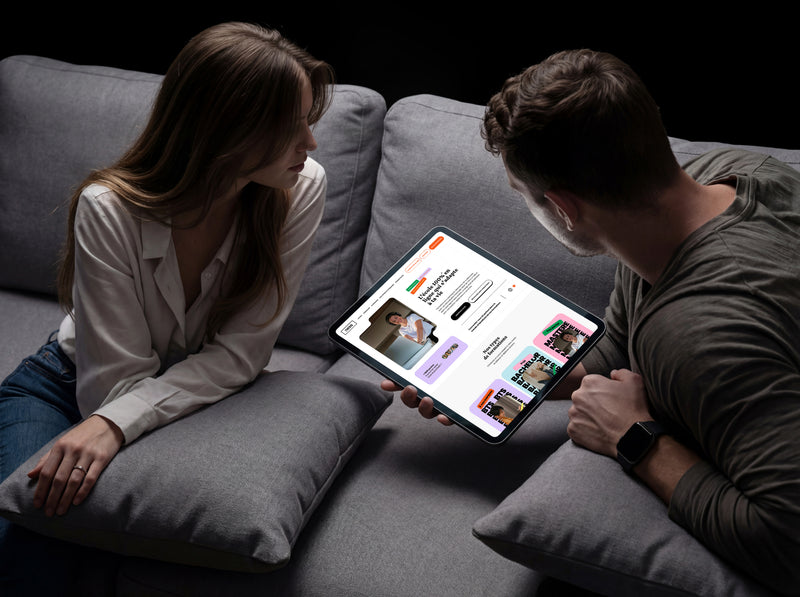 Couple consultant sur tablette le site de l'école en ligne Ness, présentant ses formations BTS, Bachelor et Mastère.