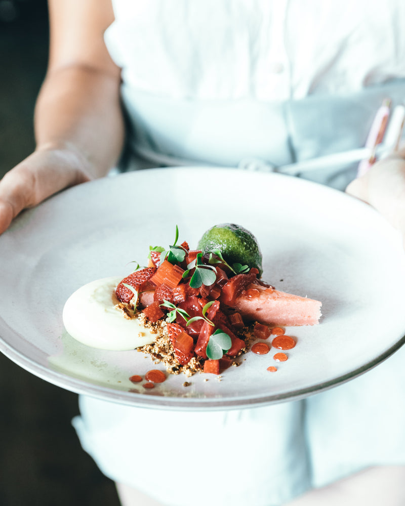 Plat gastronomique dressé par un chef et présenté sur une grande assiette dans un restaurant gastronomique.