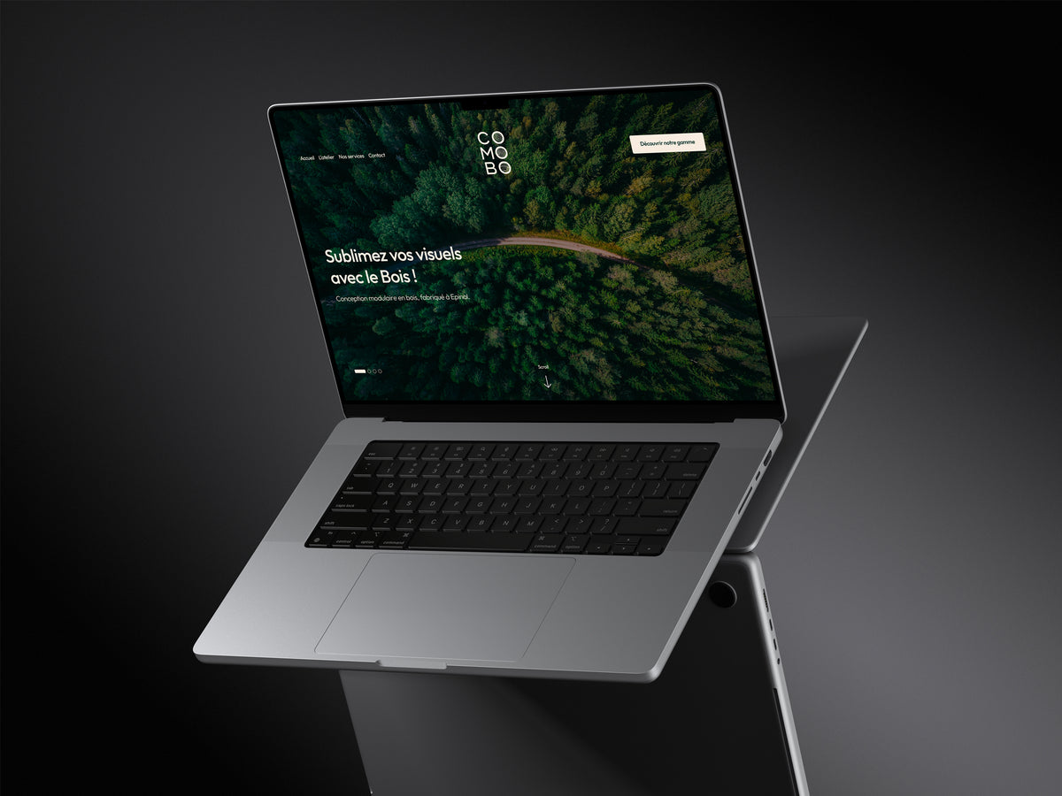 Ordinateur portable argenté ouvert affichant la page d’accueil du site COMOBO avec une photo aérienne de forêt, le logo vertical “COMOBO”, et le texte “Sublimez vos visuels avec le Bois !” fond sombre, reflet sous l’appareil.