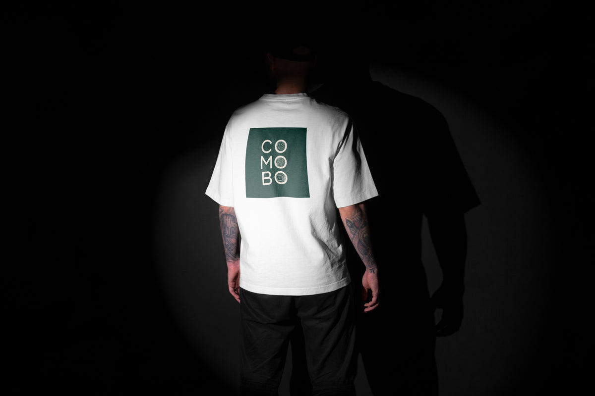 Homme de dos portant un t-shirt blanc avec un logo vert 