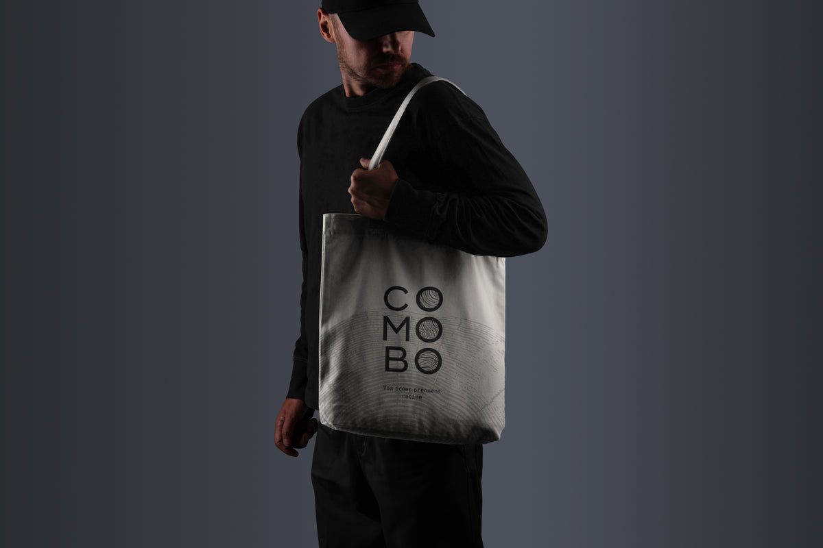 Homme portant un tote bag blanc avec le logo 