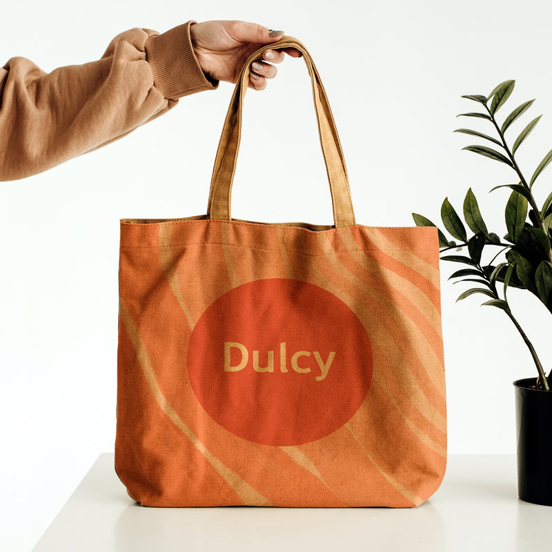 Tote bag Dulcy avec identité visuelle imprimée, exemple de support de communication et merchandising de marque.