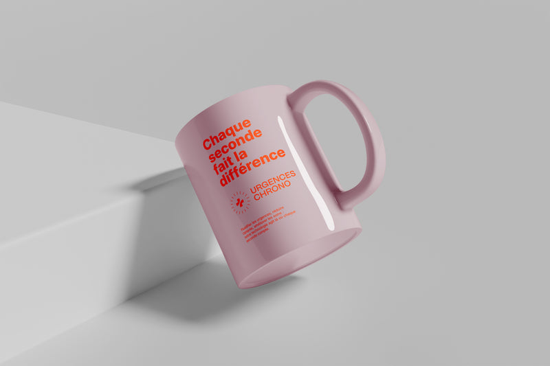 Mug rose Urgences Chrono incliné, vue rapprochée du slogan et du logo.